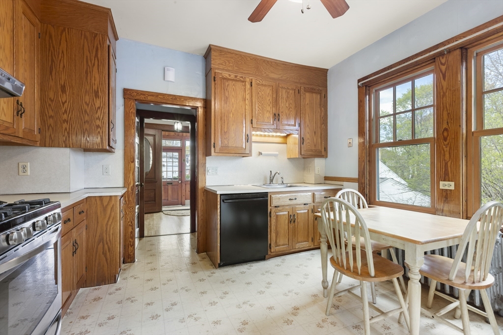 54 Oak Street Dedham, MA 02026 - Photo 15 of 36 a kitchen with granite countertop a stove a sink a dining table and chairs
