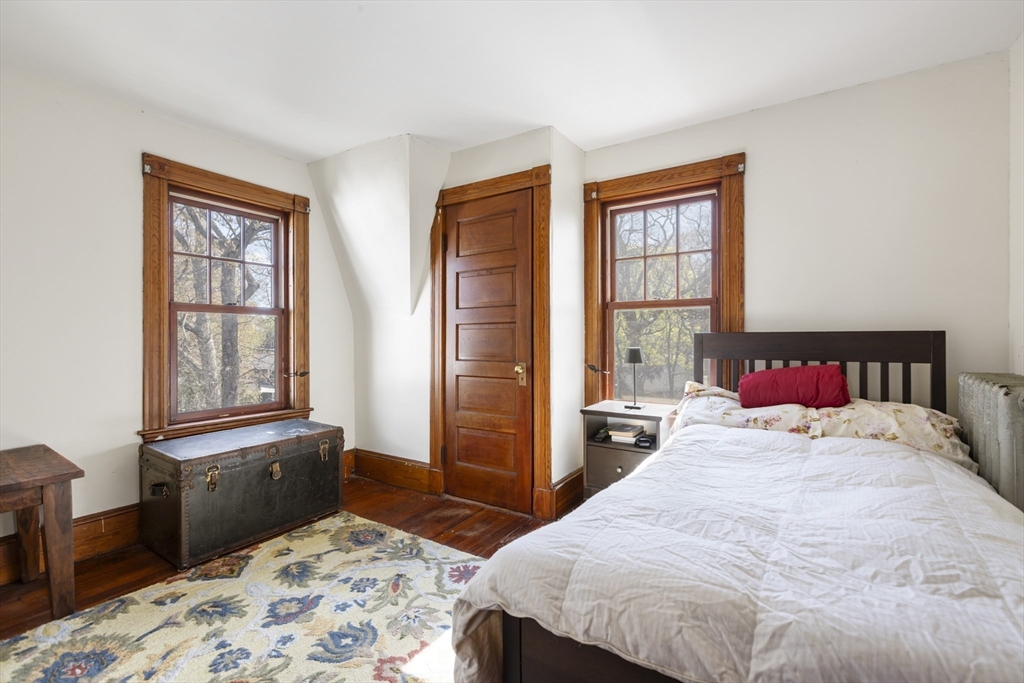 54 Oak Street Dedham, MA 02026 - Photo 18 of 36 a bedroom with a bed and wooden floor