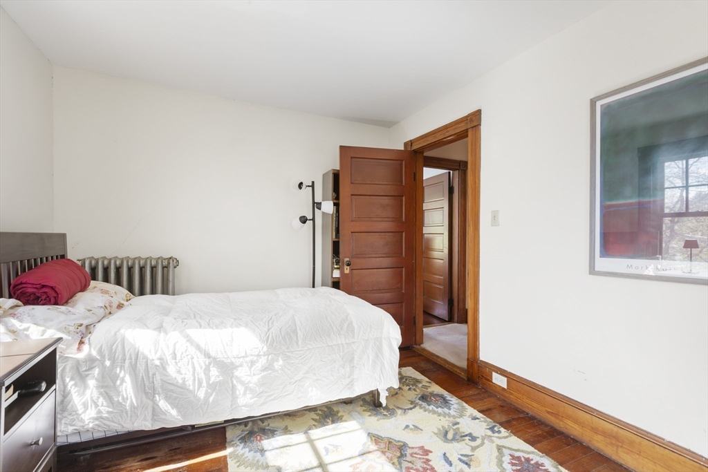 54 Oak Street Dedham, MA 02026 - Photo 19 of 36 a bedroom with a bed and wooden floor