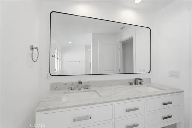 a bathroom with a granite countertop sink vanity and mirror