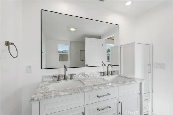 a bathroom with a granite countertop sink and a mirror