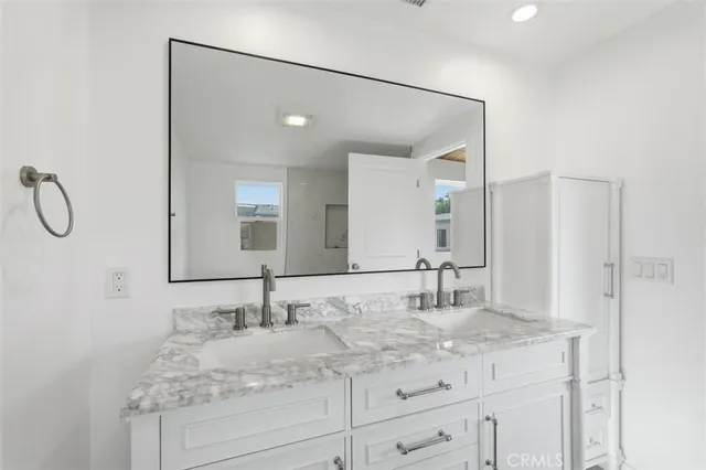 a bathroom with a granite countertop sink and a mirror