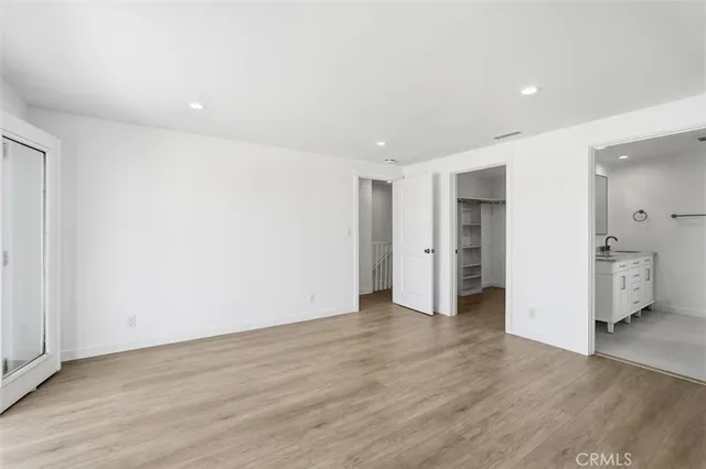 a view of a big room with wooden floor and a refrigerator