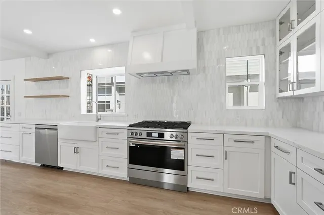 a kitchen with white cabinets and appliances