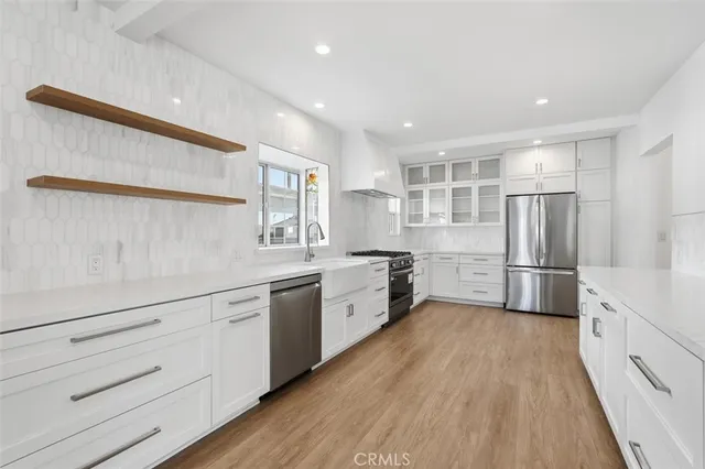 a kitchen with white cabinets and stainless steel appliances
