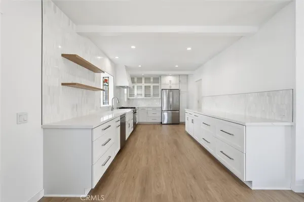 a kitchen with white cabinets and white appliances