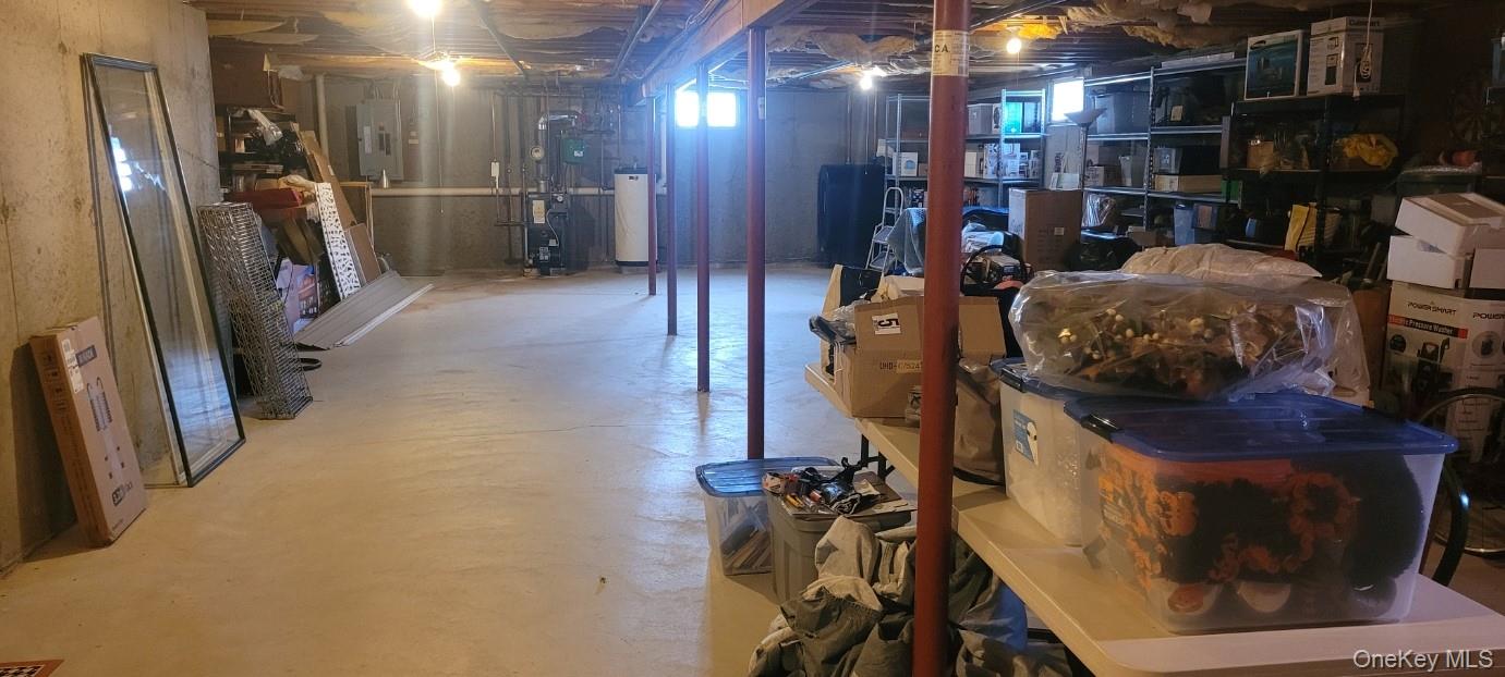 312 Riley Avenue Calverton, NY 11933 - Photo 18 of 30 Expansive unfinished basement featuring a concrete floor, exposed high ceiling joists, and structural support columns