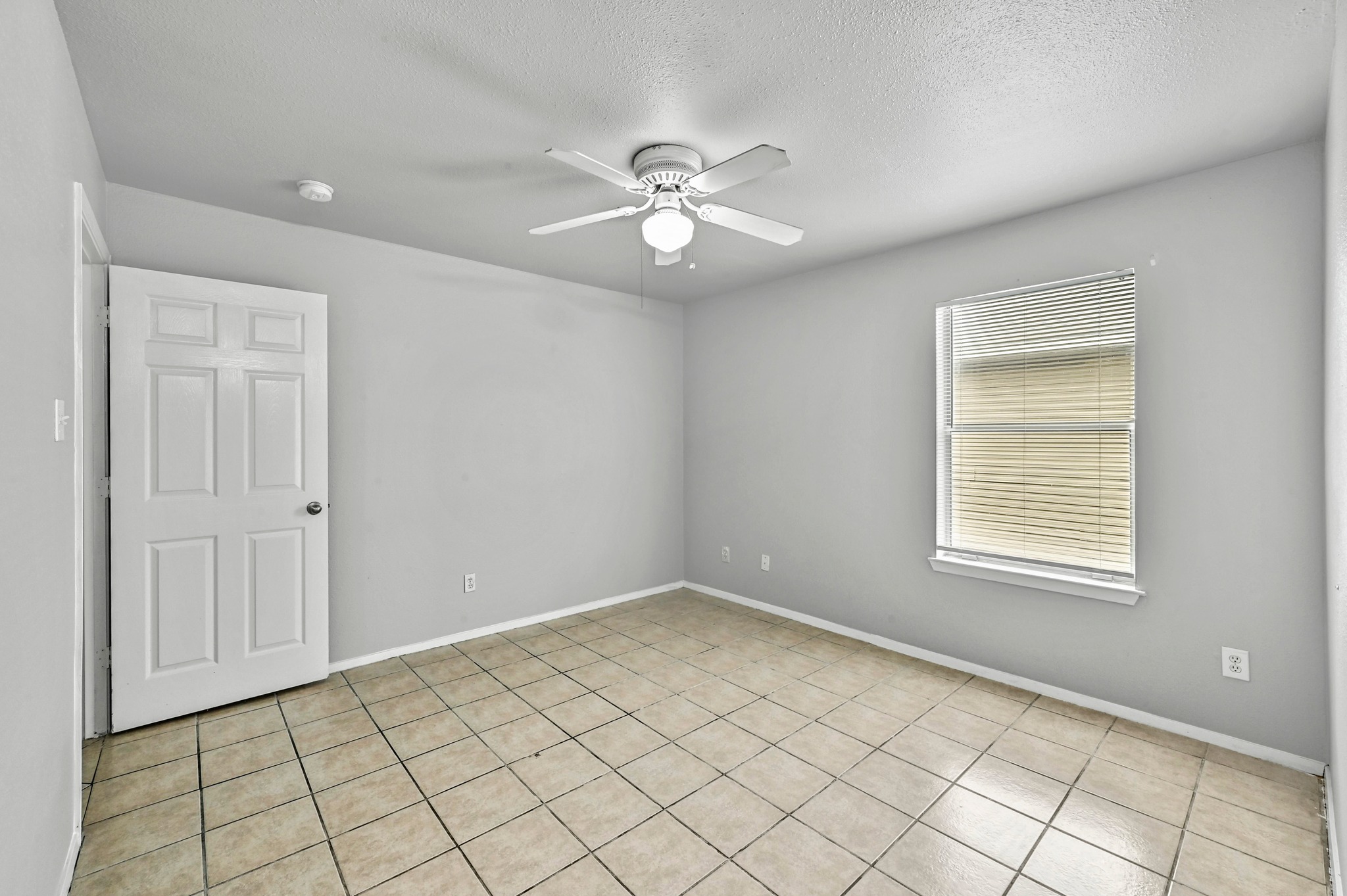 2212 Katy Lane Georgetown, TX 78626 - Photo 19 of 27 This room features light-colored tile flooring, a window with blinds, and a ceiling fan with an integrated light fixture