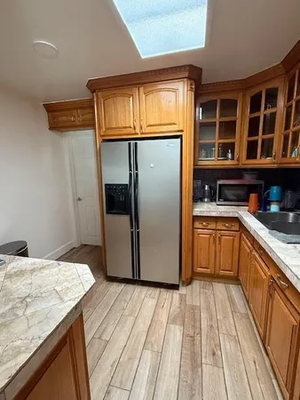 a kitchen with granite countertop wooden cabinets and white appliances