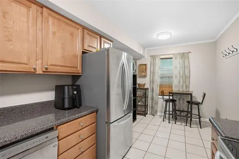 a kitchen with granite countertop a refrigerator and a stove top oven