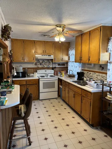 a kitchen with a sink a counter top space cabinets and appliances