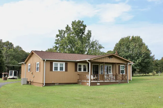 a front view of a house with a garden and trees