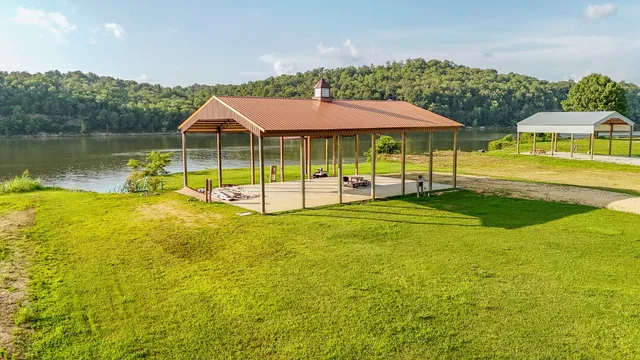 a view of a swimming pool with lawn chairs under an umbrella