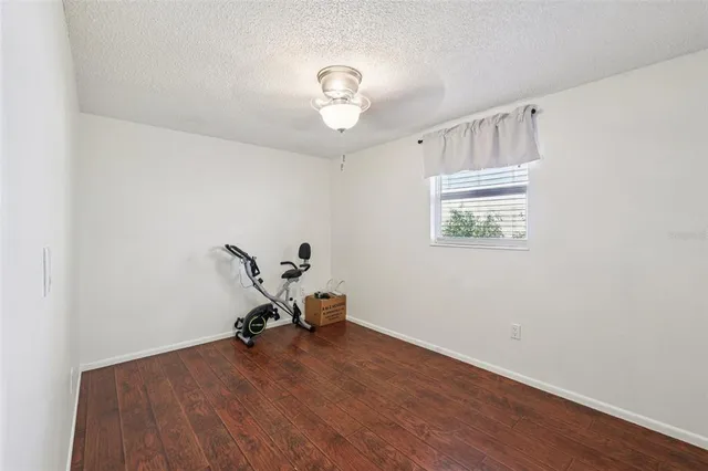 a living room with wooden floor and a chandelier