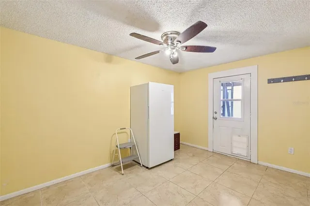 a view of a livingroom with a chandelier fan and windows