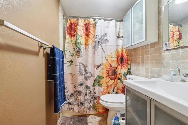 a bathroom with a sink toilet and shower