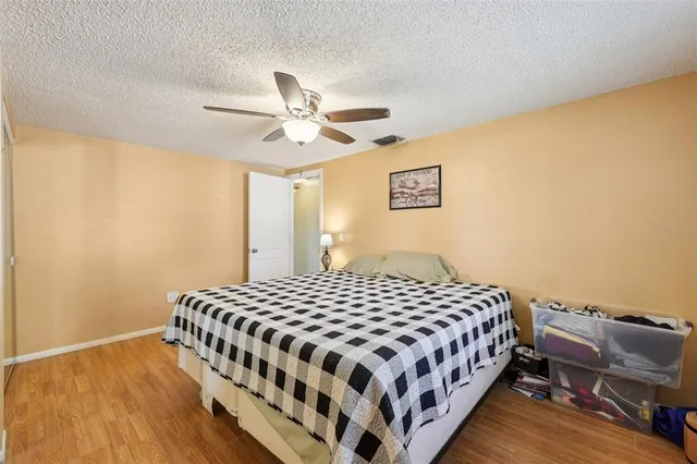 a bedroom with a bed and wooden floor