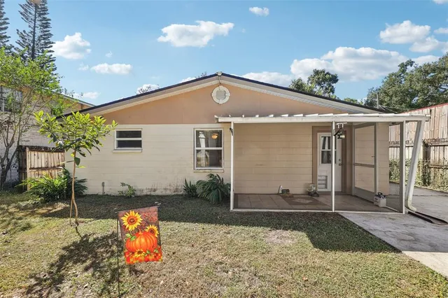 a view of a house with backyard and sitting area