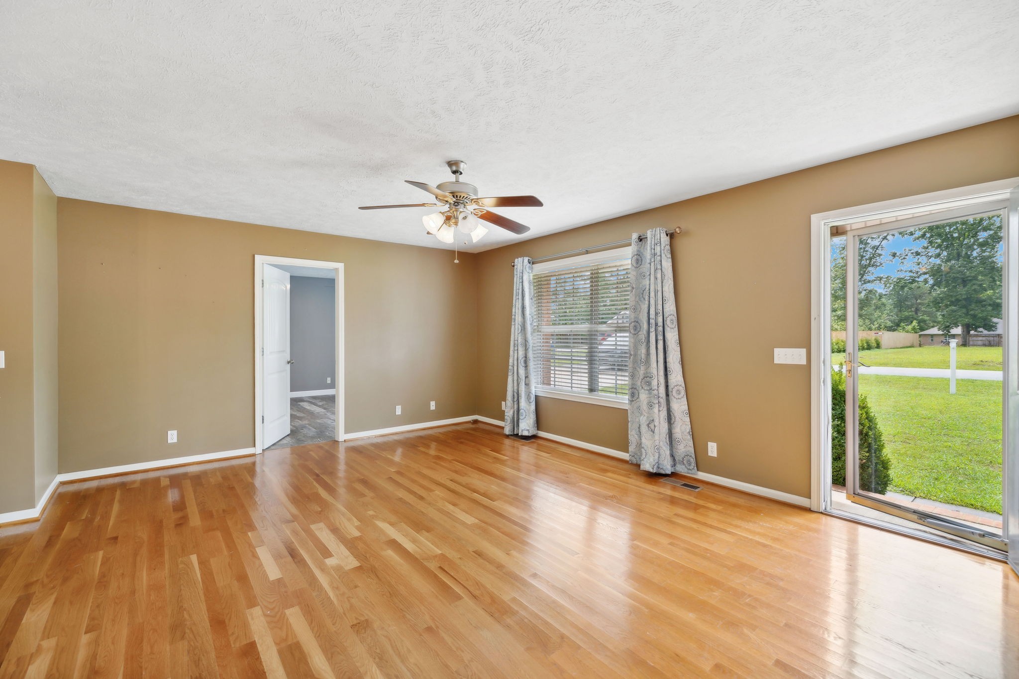 373 Oak Hollow Road Manchester, TN 37355 - Photo 5 of 34 a view of an empty room with a window and wooden floor