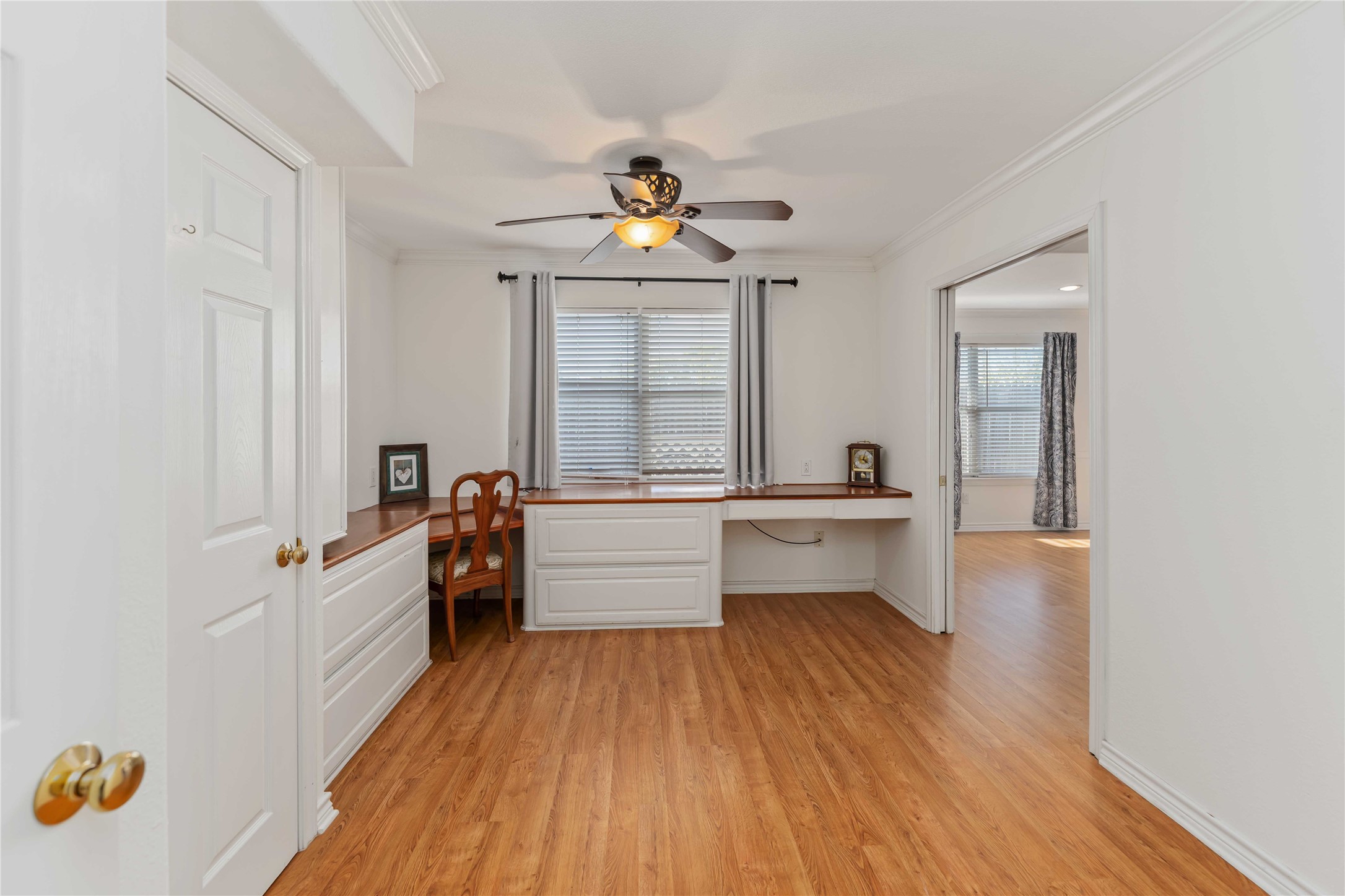 606 Packer Court Webster, TX 77598 - Photo 16 of 28 This bright room features a built-in desk and shelving, complemented by warm wood flooring. Ideal for a home office, a study space, or extra bedroom.