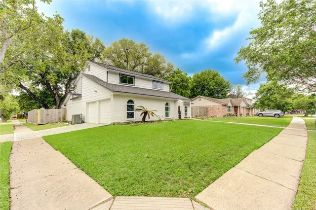 a front view of a house with a yard and trees