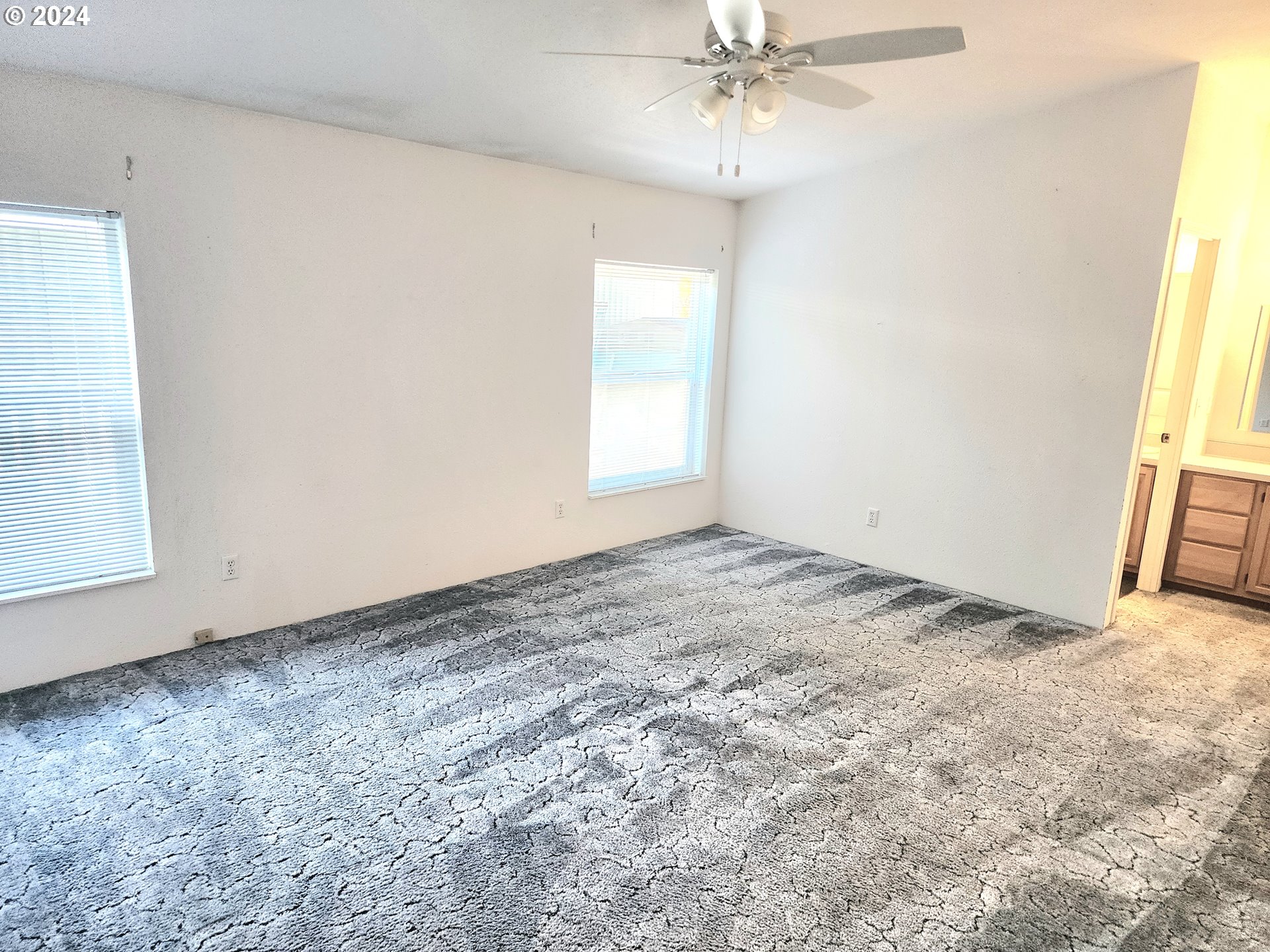 1475 Green Acres Road, Unit 69 Eugene, OR 97408 - Photo 11 of 15 an empty room with a chandelier fan and windows