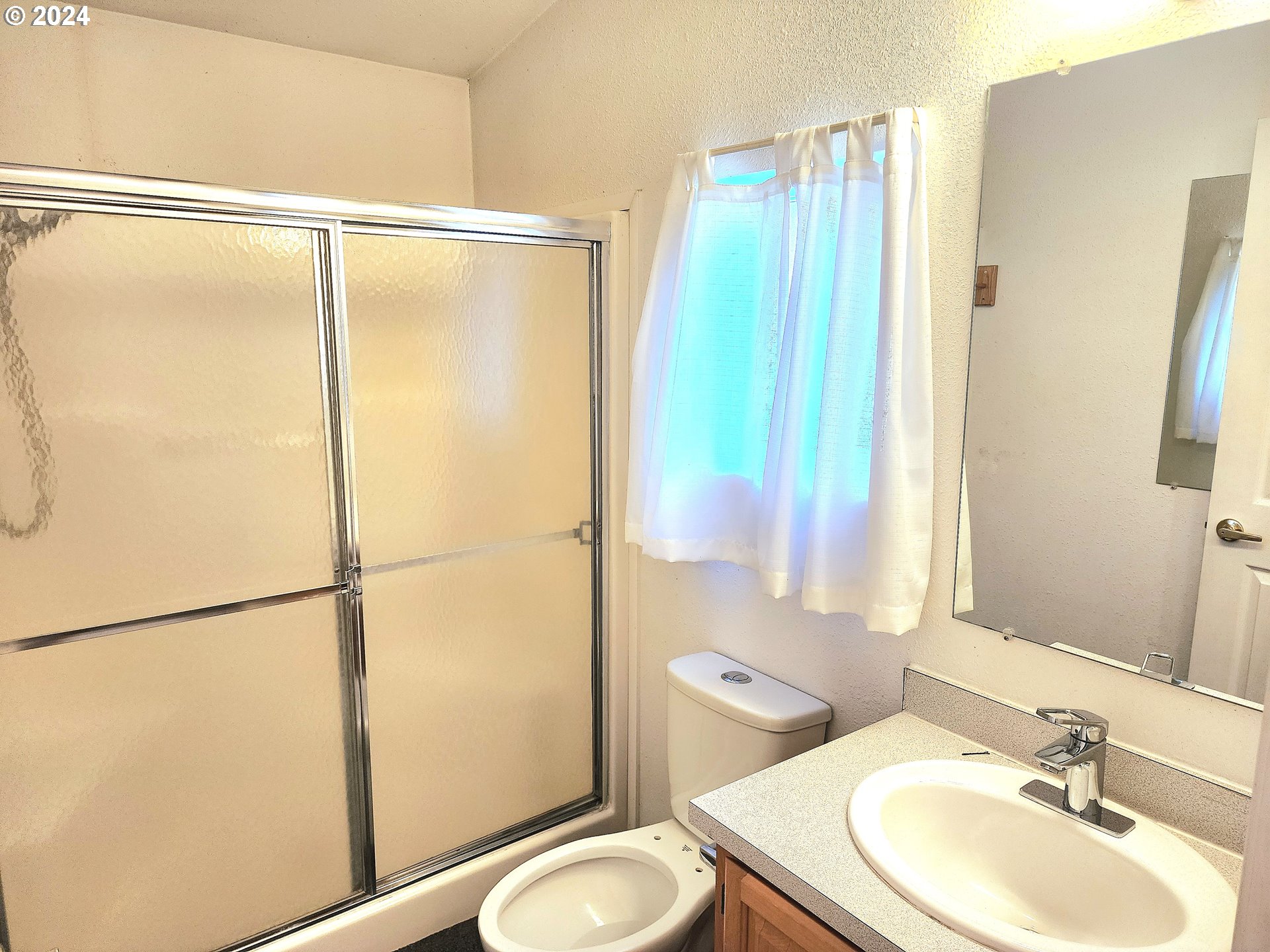 1475 Green Acres Road, Unit 69 Eugene, OR 97408 - Photo 15 of 15 a bathroom with a sink mirror vanity and toilet