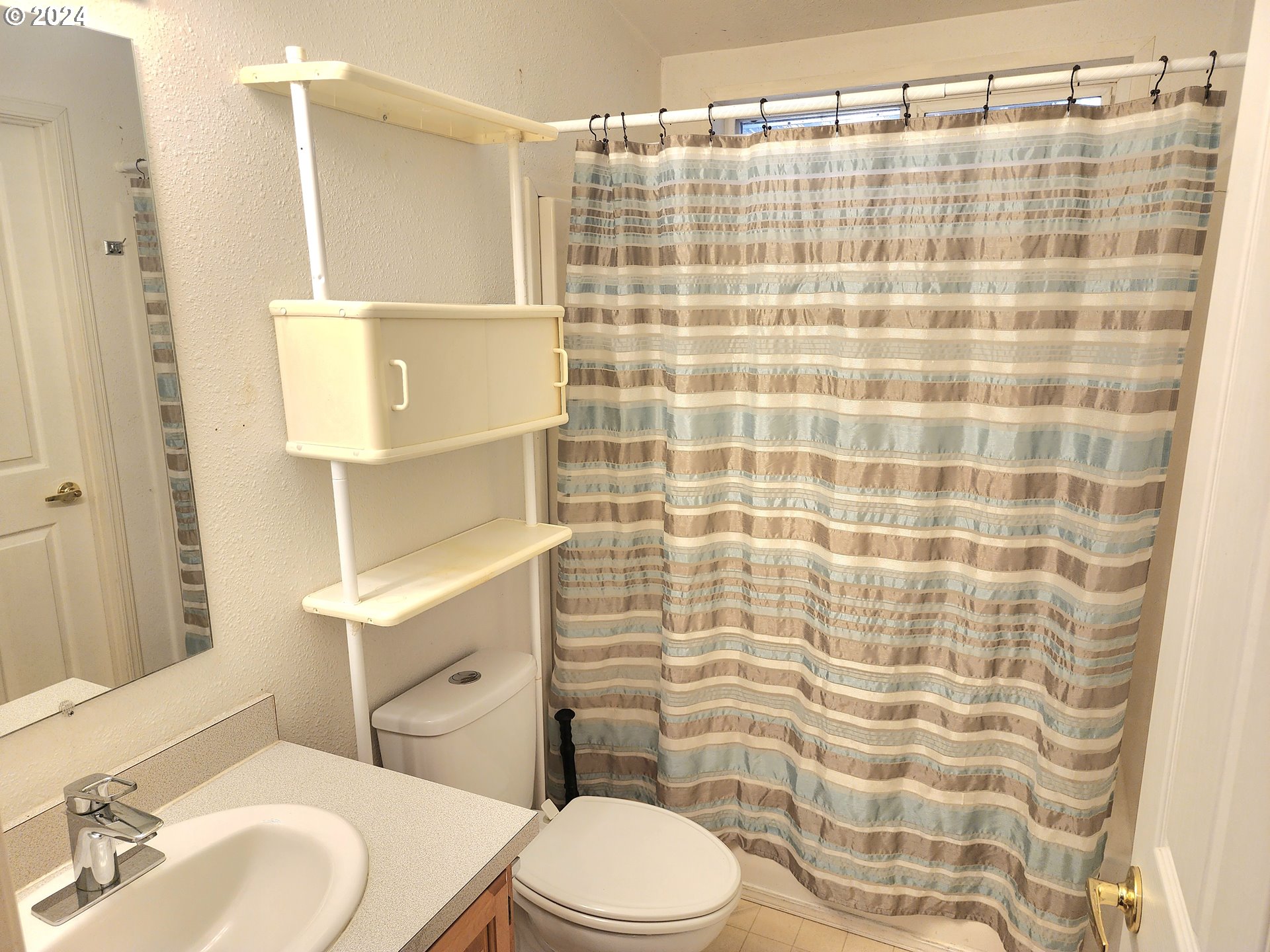 1475 Green Acres Road, Unit 69 Eugene, OR 97408 - Photo 10 of 15 a bathroom with a sink a toilet and shower curtain