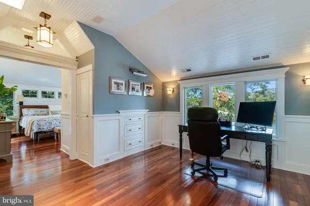 a view of a house with a yard and large trees