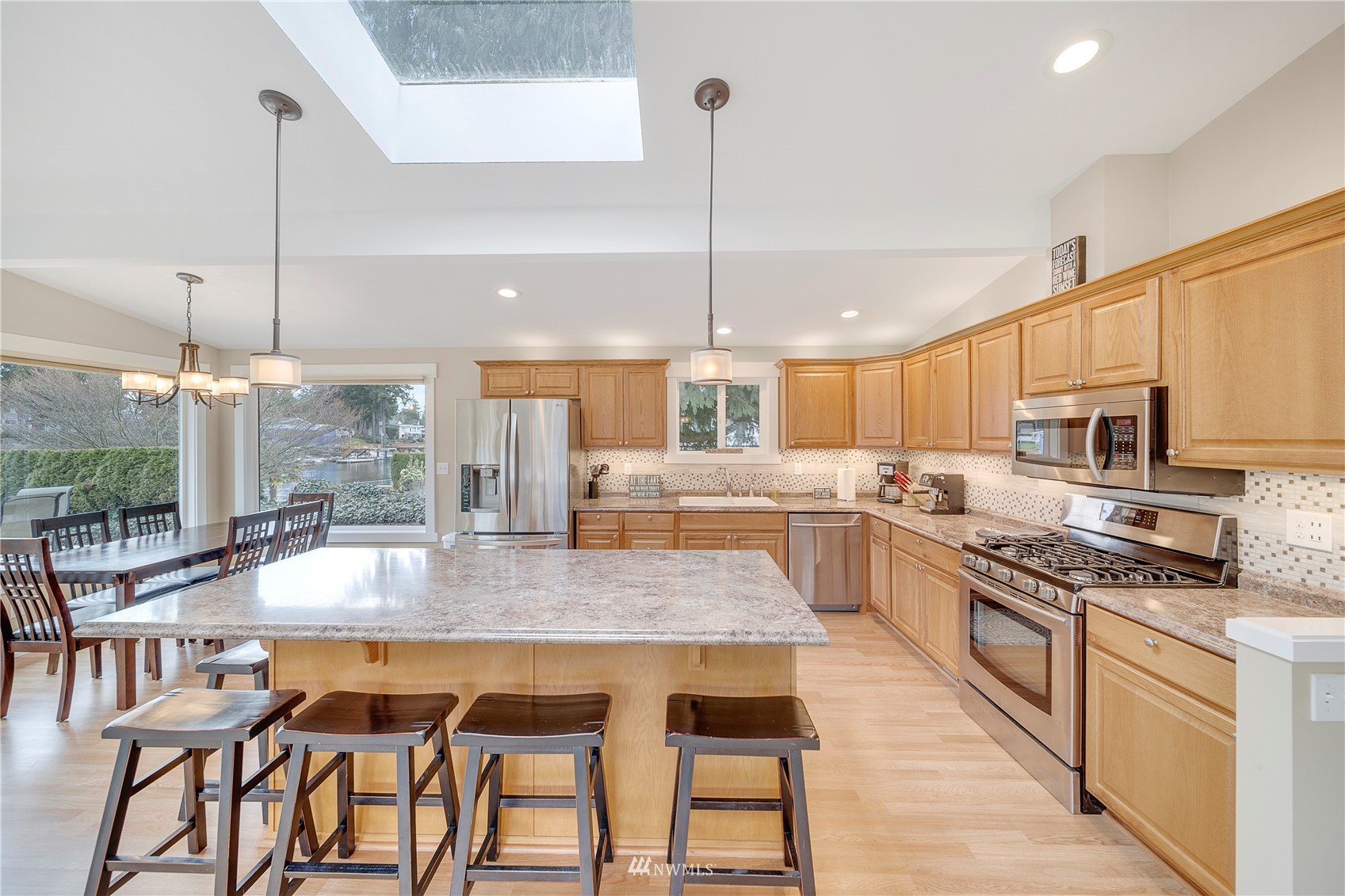 1919 Channel Road East Lake Tapps, WA 98391 - Photo 8 of 33 a kitchen with stainless steel appliances granite countertop a kitchen island a stove and a wooden floors