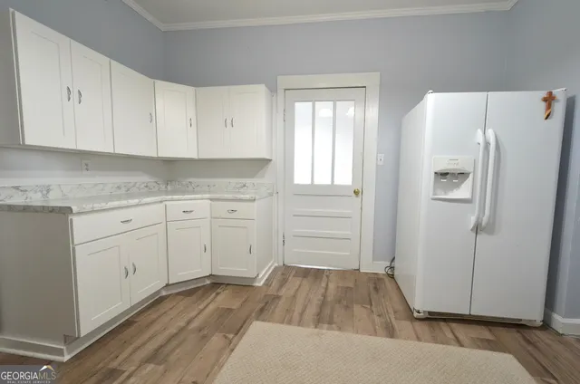 a kitchen with white cabinets and white appliances