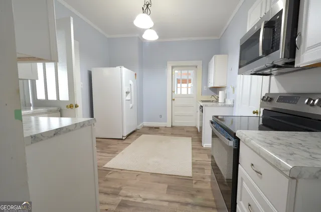 a kitchen with granite countertop a sink stainless steel appliances a counter space and cabinets