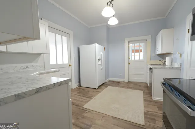 a large kitchen with granite countertop a stove a sink and a refrigerator