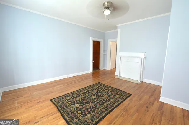 an empty room with wooden floor and window