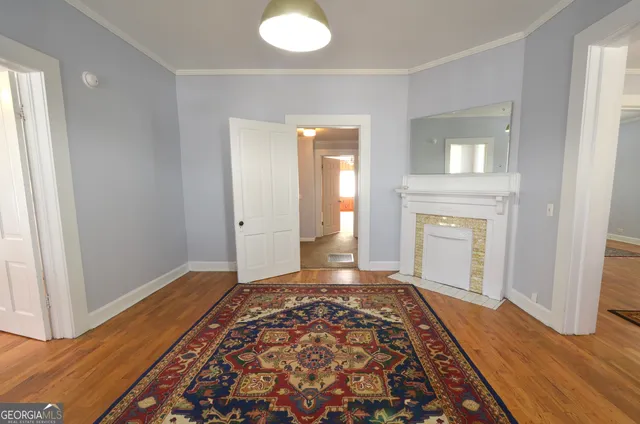 a view of a livingroom with wooden floor and a rug