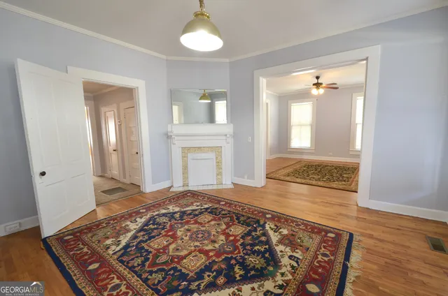 a view of a livingroom with wooden floor and a rug