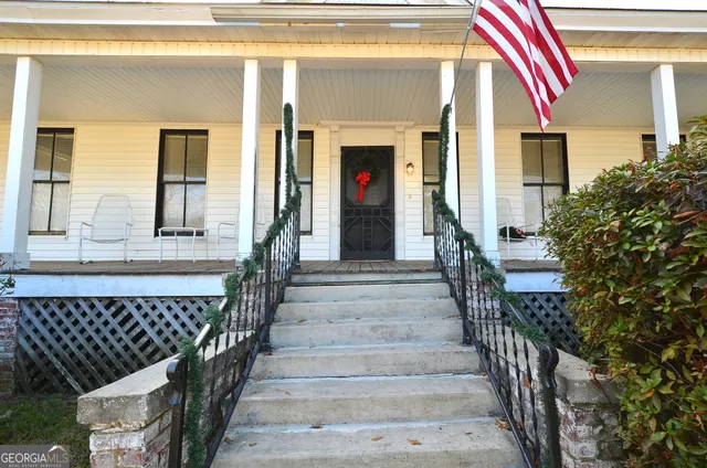 a view of a house with entryway and wooden door
