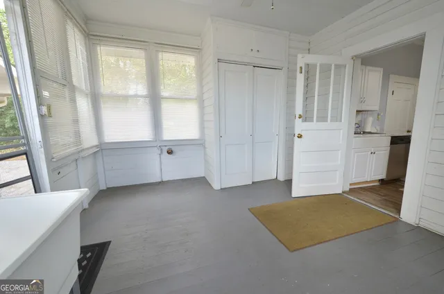 a view of a yard with plants and large trees