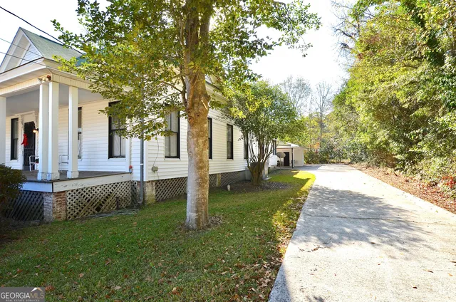 a view of a house with backyard and a tree