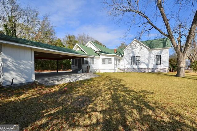 a front view of house with yard and trees around