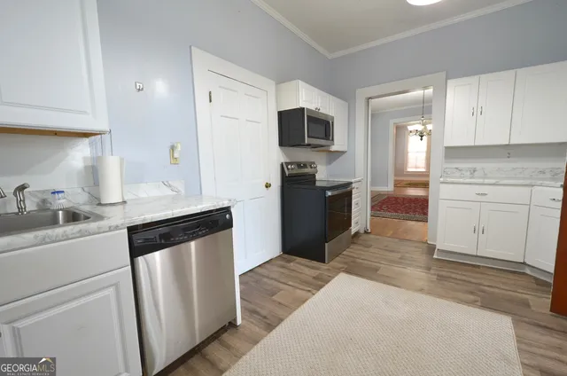 a kitchen with white cabinets and stainless steel appliances