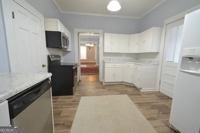 a kitchen with granite countertop a refrigerator and a stove top oven
