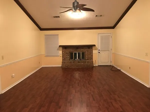 a view of empty room with wooden floor and fireplace