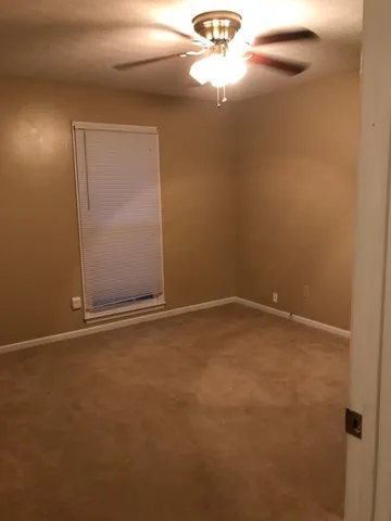 an empty room with a chandelier fan