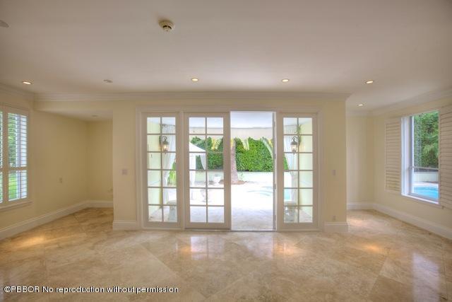 112 Caribbean Road Palm Beach, FL 33480 - Photo 3 of 6 a view of an empty room with a sliding door and wooden floor
