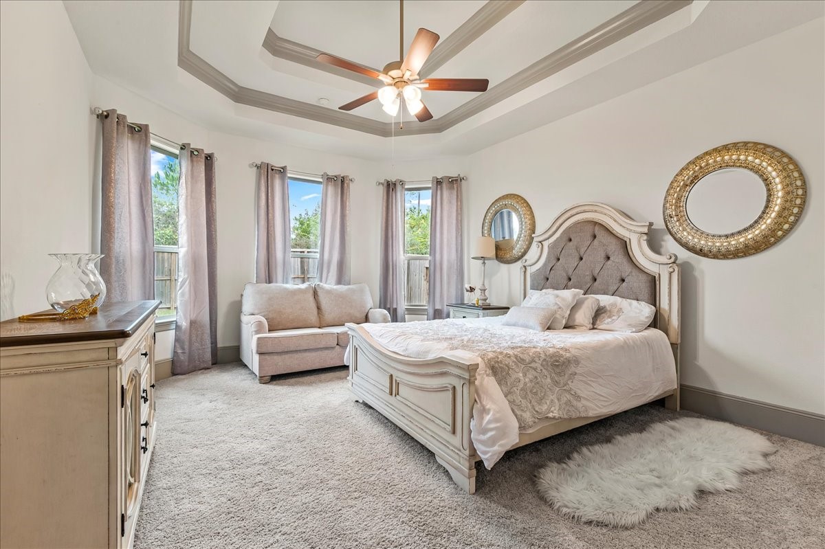 712 Fall Rock Branch Drive Conroe, TX 77304 - Photo 12 of 23 a bedroom with a large bed and a chandelier