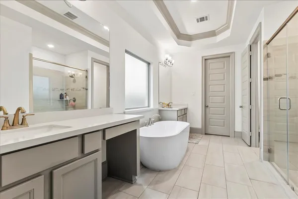 a large spacious bathroom with a double vanity sink a large mirror and a bathtub