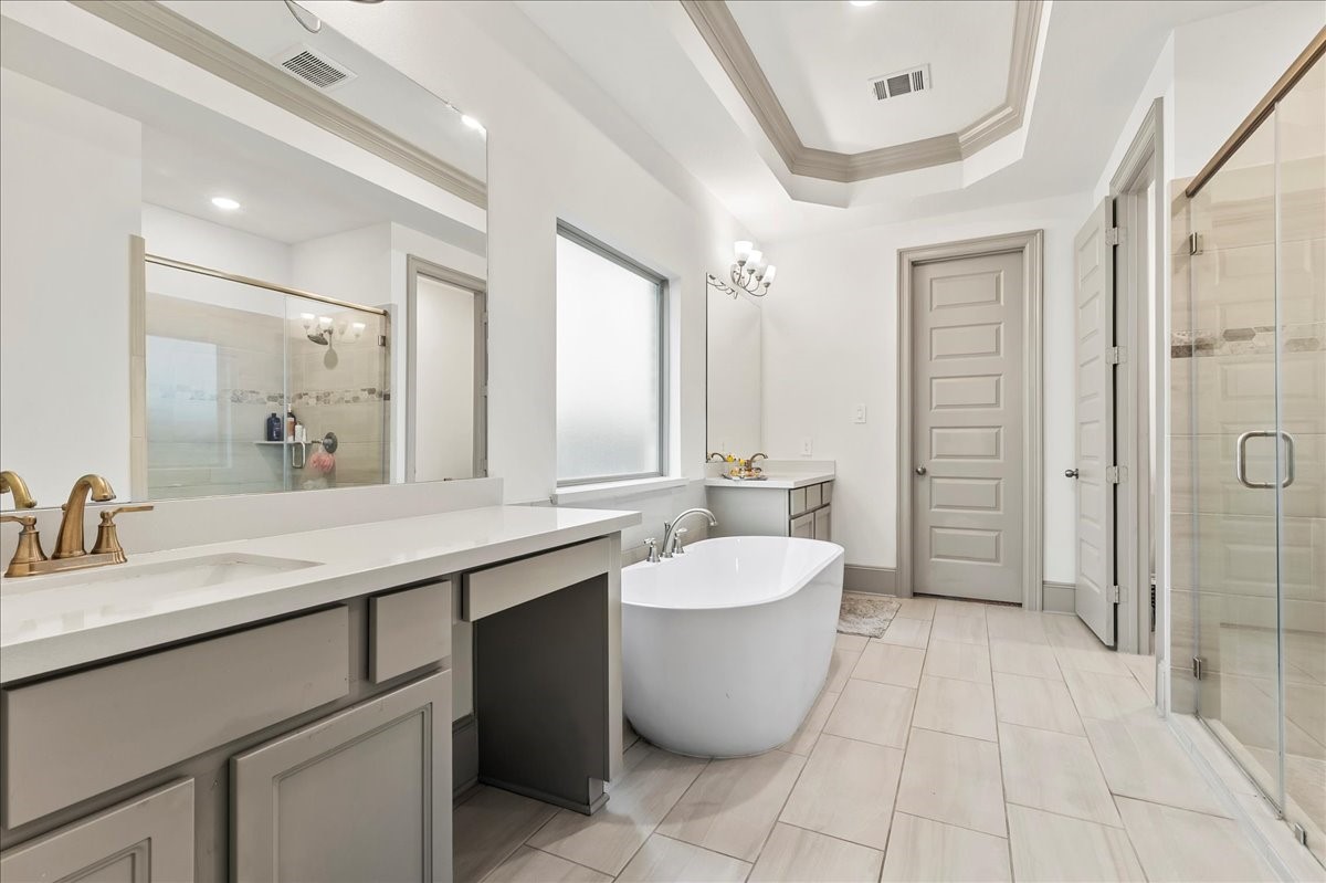 712 Fall Rock Branch Drive Conroe, TX 77304 - Photo 13 of 23 a large spacious bathroom with a double vanity sink a large mirror and a bathtub