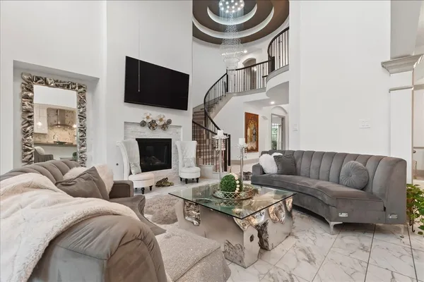 a living room with furniture a flat screen tv and a fireplace