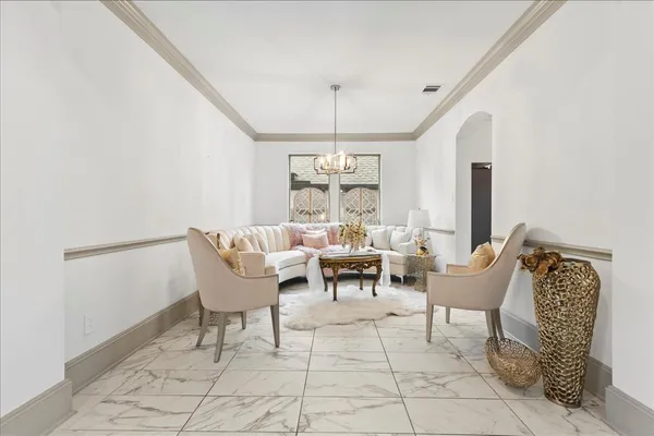 a living room with furniture and a chandelier